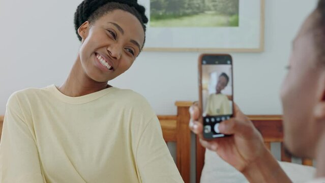 Phone, photograph and love with a black couple bonding and being playful in the bedroom of their home. Mobile, picture and joking with a young man and woman taking a photo on a smartphone together