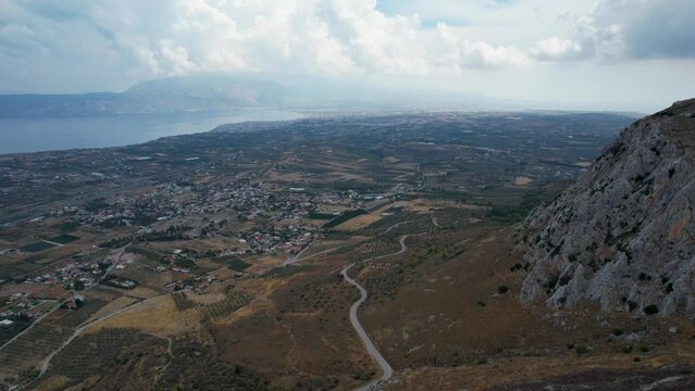 Aerial view of the imposing ancient site of Acrocorinth towards Corinth, Corinthia, Peloponnese, Greece, in summer. Sunny day over ancient fort