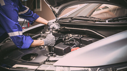Car care maintenance and servicing, Close-up hand technician auto mechanic using the wrench to...