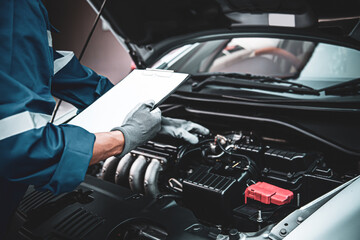 Car care maintenance and servicing, Close-up hand technician auto mechanic checking inspection list after repairing change spare part car engine problem and car insurance service.