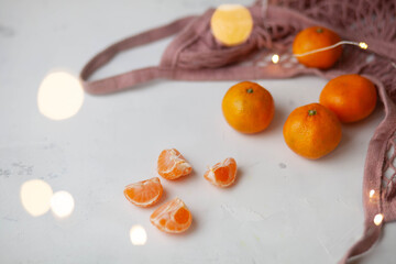 mandarins in a pink string bag and garland light bokeh