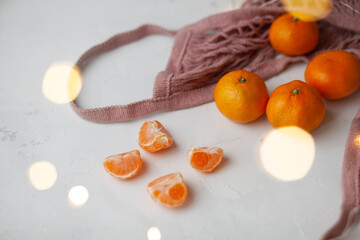 mandarins in a pink string bag and garland light bokeh