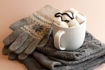 mug full of marshmallow hot chocolate and winter gloves