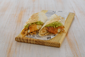 chiken fajita with avocado on a wood plate