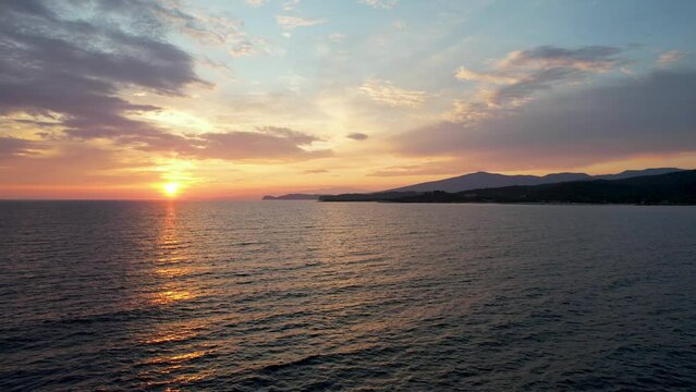 Aerial view of a sunset over a beautiful sea with waves. Tropic nobody nature seascape. Thassos island in Greece. Golden hour