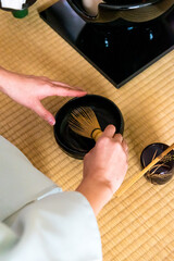 Japanese woman, tea master, Sen Rikyu, hands purifying a chasen, bamboo matcha whisk in Japanese traditional tea ceremony © A Certain Aesthetic