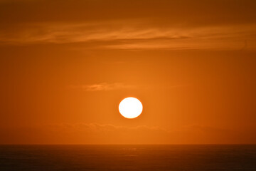 The sun rises over the ocean.