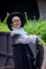 Asian children boy in Count Dracula dress costume for Halloween decoration in graden