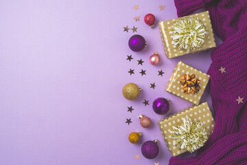 Obraz na płótnie Canvas Happy New Year and Merry Christmas background with golden gift boxes, ornaments and purple warm sweater. Top view, flat lay