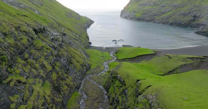 Aerial Forward Descending Beautiful View Of Sea Amidst Mountains - Faroe Islands, Denmark