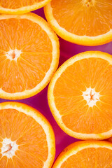 Naranjas frescas cortadas al medio sobre fondo violeta. Recurso gráfico para anuncios y flyer	