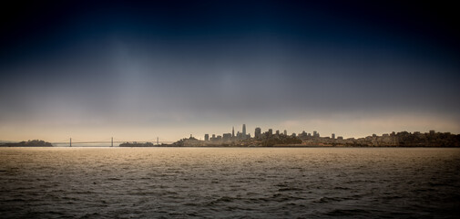 Skyline of San Francisco, California, with deep blu Sky and moody foggy Atmosphere 