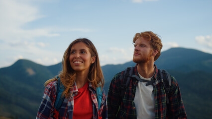 Smiling couple hiking summer mountains closeup. Young travelers explore nature