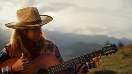 Closeup musical woman play guitar instrument in mountains. Girl compose music.