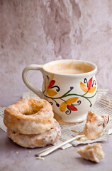 Café con leche en taza pintada a mano y rosquillas