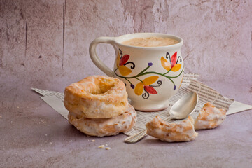 Café con leche en taza pintada a mano y rosquillas