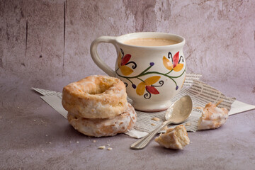Café con leche en taza pintada a mano y rosquillas