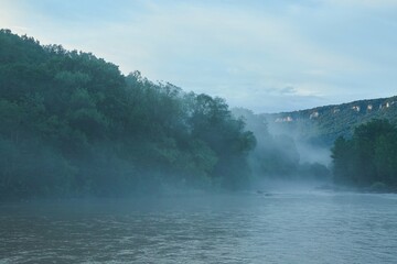 A swift mountain river. Water flows in nature. Mountainous terrain.