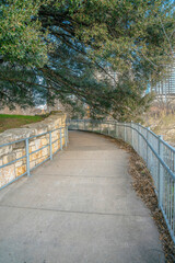 Fototapeta na wymiar Austin, Texas- Concrete walkway with metal railings along the trees on the side