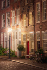 Fototapeta na wymiar historic street view at night illuminated by an old-fashioned street lamp in Dordrecht