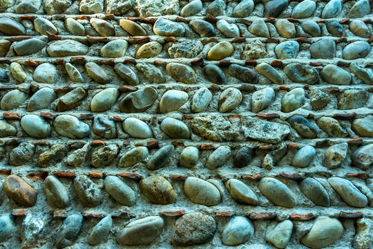 Architectural detail of a medieval stone house in Perouges, France. The wall is made of cobblestones disposed in diagonal (galets hourd&eacute;s in French).