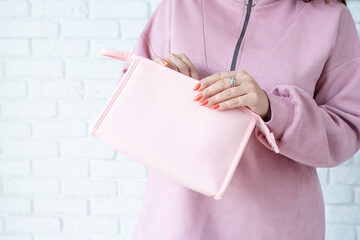 closeup woman in pink clothes hands holding pink toiletry bag for mockup design