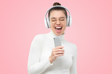 Girl in turtleneck listening to music in headphones, singing to favorite song in online karaoke app