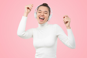 Young woman shouting and laughing with pleasure, enjoying favorite music in headphones, dancing