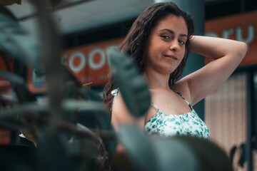 Selective focus shot of a Caucasian female wearing a two-piece sleeveless dress in a mall