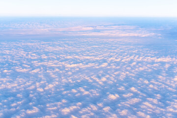 Background of a pink heavenly sky with fluffy dense clouds, top view from an airplane. Can be used as advertising background, overlay. Travel concept.