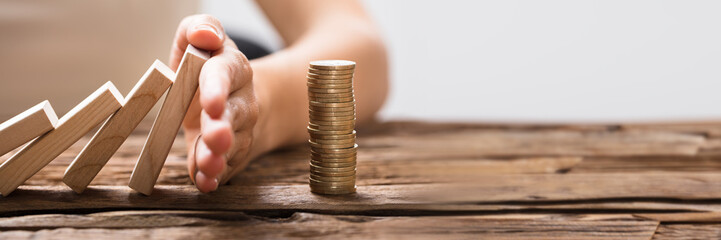 Close-up Of A Businesswoman's Hand Stopping Falling Blocks