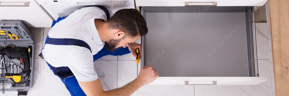 Poster Carpenter Fixing Drawer In Kitchen