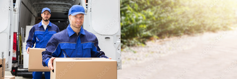 Wall mural Close-up Of Two Delivery Men Carrying Cardboard Box