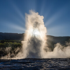 Strokkur Geyser Iceland, evening sunrays shining through the water column