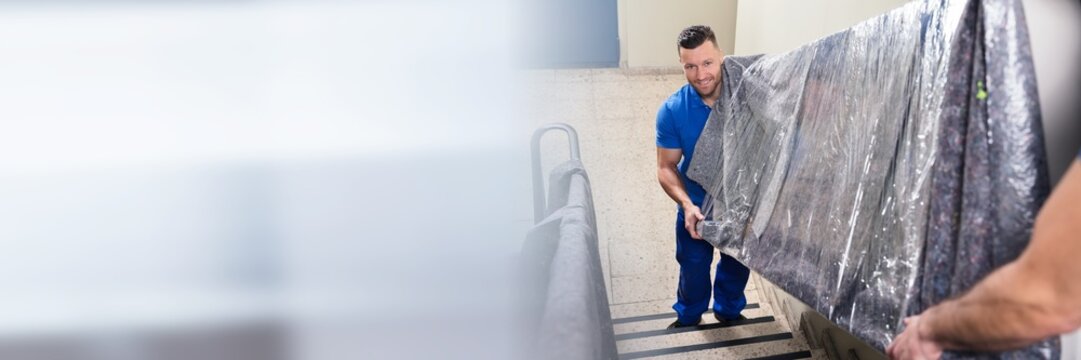 Two Movers Carrying Furniture On Staircase