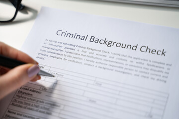 Human Hand Filling Criminal Background Check Application Form