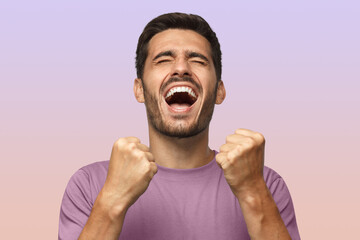 Man isolated on purple background shouting with closed eyes, celebrating victory, squeezing fists
