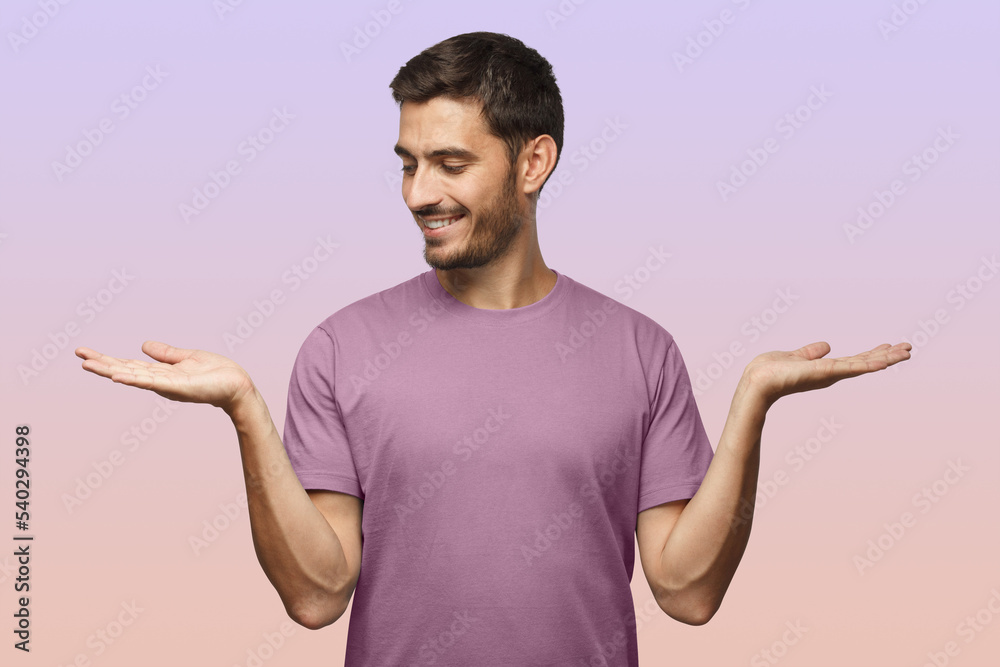 Wall mural man choosing between 2 different options, holding two hands with empty space on purple background