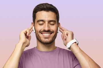 Close up of smiling young man in t-shirt listening favourite song or cool track, feeling rhythm