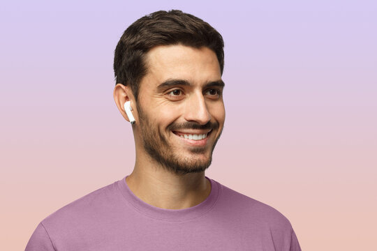 Close up headshot of smiling man wearing t-shirt, listeting to his favorite music track