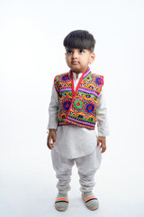 Cute indian little child in ethnic wear and showing expression over white background