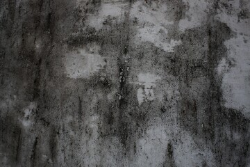 A weathered concrete wall with cracks and peeling paint, showing signs of age and decay.