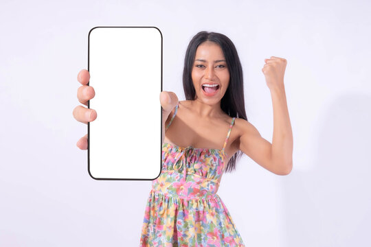 Beautiful Asian brunette woman cute girl in pink dress ,Excited surprised girl showing big smart phone with blank screen , white screen isolated on white background , Display Mock Up Image