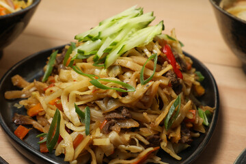 Nouilles Sautées au Bœuf et Légumes (Lagman ou Lo Mein), garnies de Concombre et Ciboule