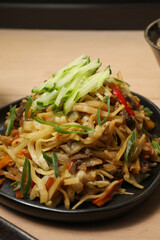 Nouilles Sautées au Bœuf et Légumes (Lagman ou Lo Mein), garnies de Concombre et Ciboule