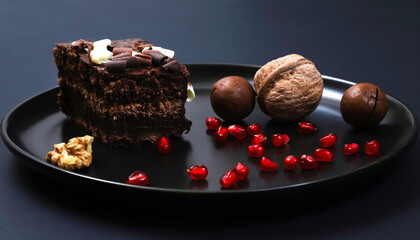 Portion of chocolate dessert cake on plates under dark lighting. Shallow depth of field