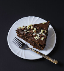 Portion of chocolate dessert cake on plates under dark lighting. Shallow depth of field