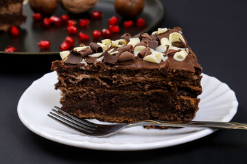 Portion of chocolate dessert cake on plates under dark lighting. Shallow depth of field