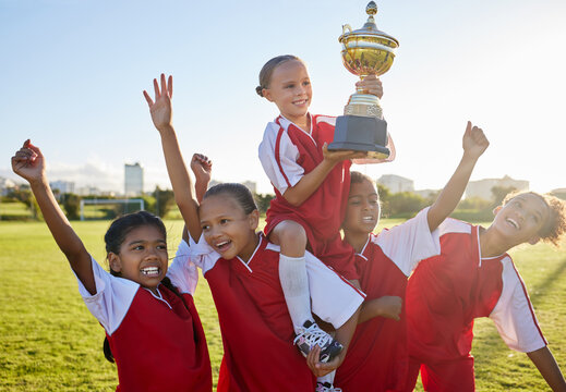 Trophy, Winner And Football Children With Success, Winning And Excited Celebration For Sports Competition Or Game On Field. Happy Soccer Girl Kids Team With Motivation, Celebrate Winning Achievement