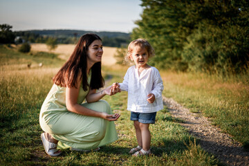 Fototapeta premium mother plays with her child in the evening park